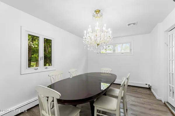 a view of a dining room with furniture a chandelier and wooden floor