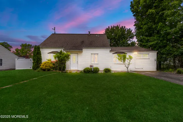 a front view of a house with a garden and plants