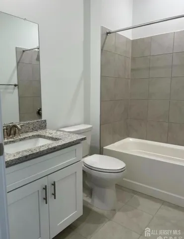 a bathroom with a granite countertop sink a toilet and bathtub