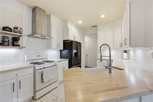 a kitchen with white cabinets and appliances