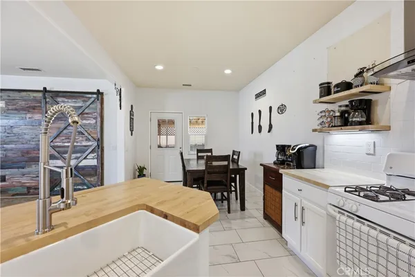 a kitchen with stainless steel appliances a stove a sink a microwave and a refrigerator
