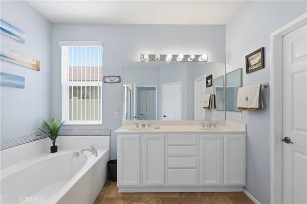 a bathroom with a tub sink and mirror