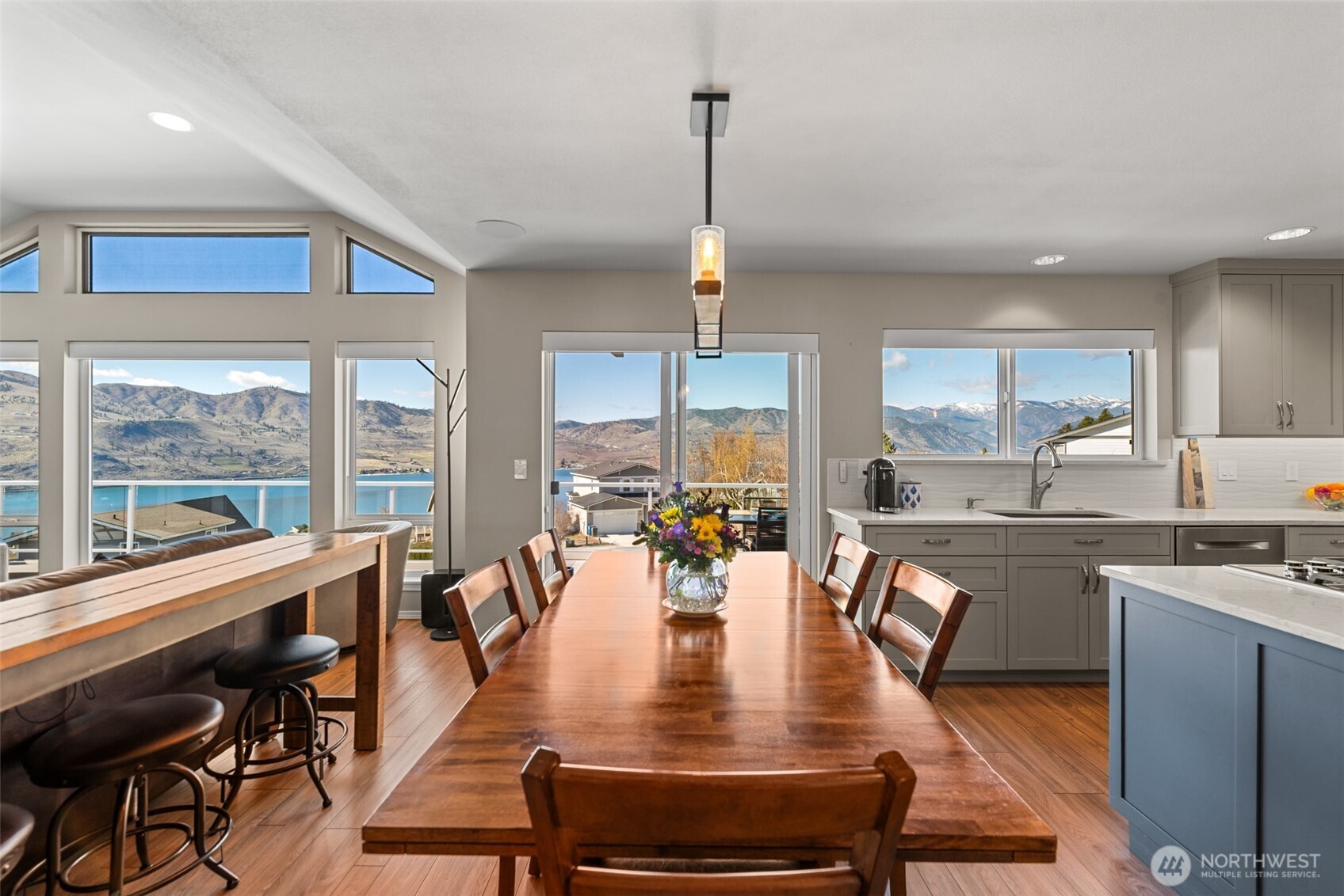 204 Stehekin Way Chelan, WA 98816 - Photo 3 of 40 a view of a dining room and livingroom with furniture wooden floor a rug a fireplace and a large window