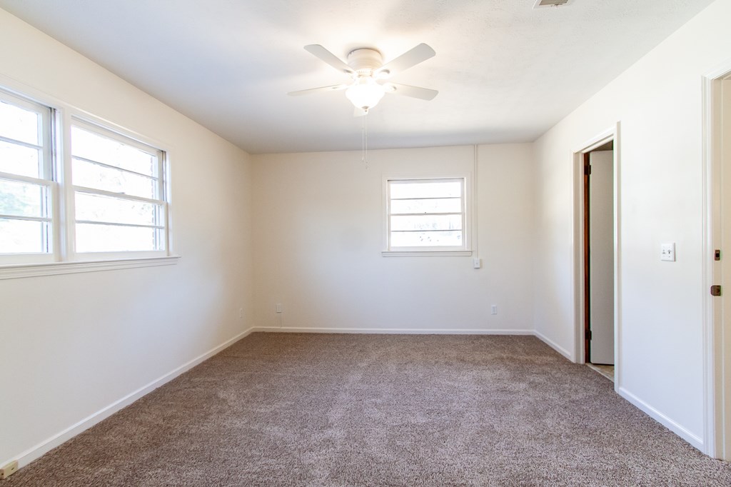 4315 Macon Road Columbus, GA 31907 - Photo 11 of 37 an empty room with windows and chandelier fan