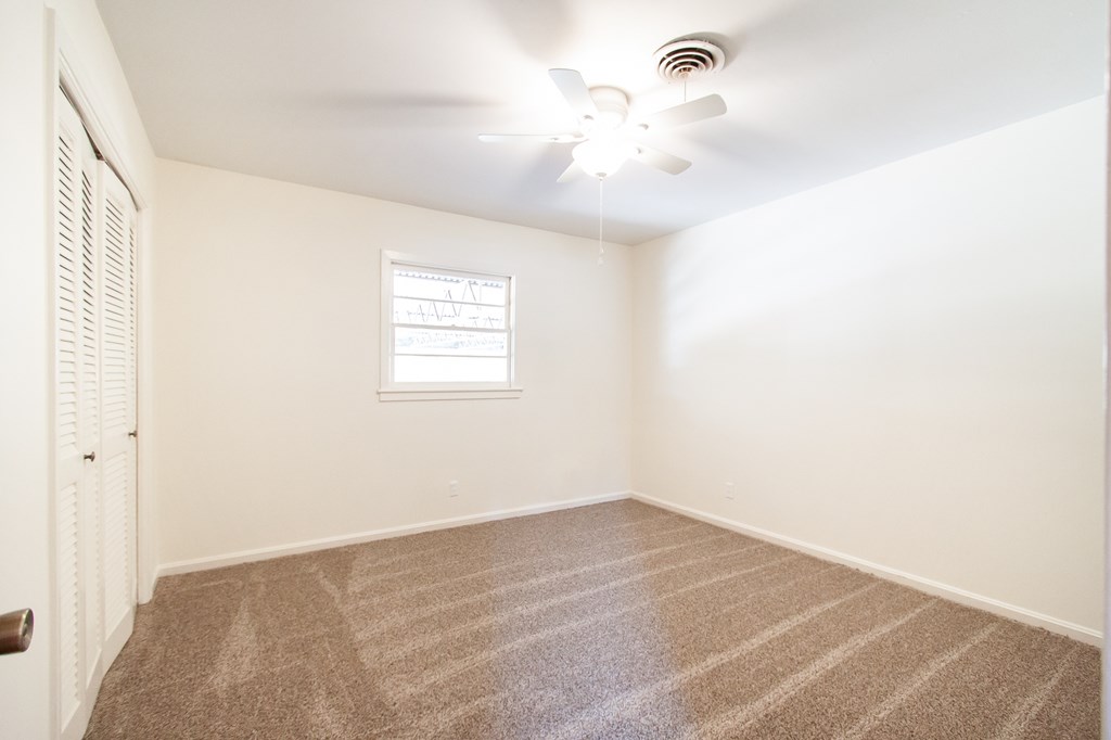 4315 Macon Road Columbus, GA 31907 - Photo 19 of 37 an empty room with a chandelier fan and windows