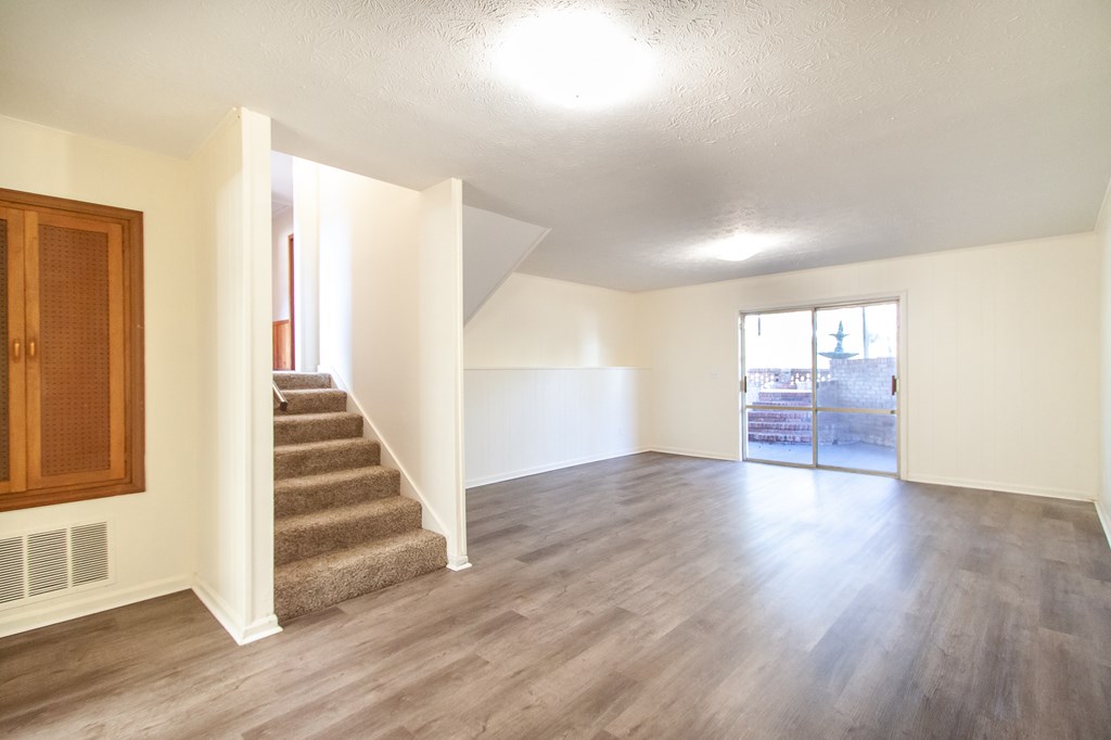 4315 Macon Road Columbus, GA 31907 - Photo 4 of 37 a view of an empty room with wooden floor and stairs