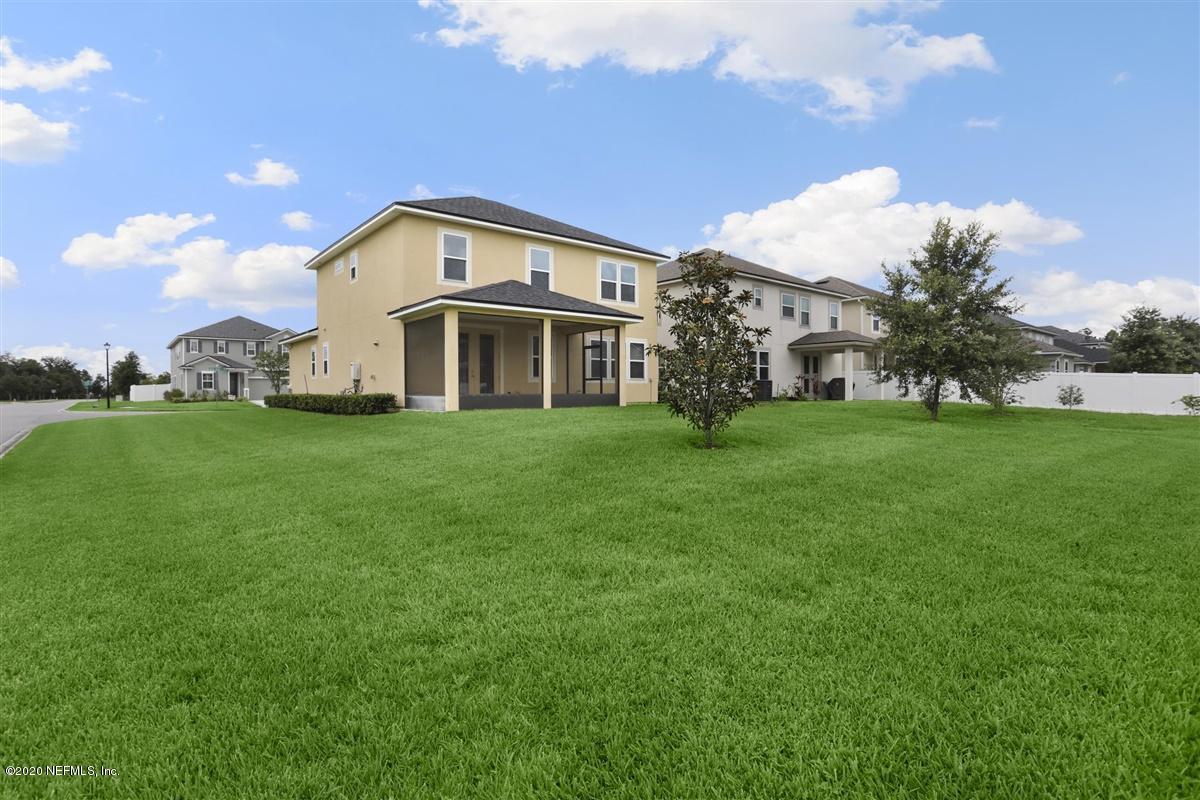 6775 Azalea Park Road Jacksonville, FL 32259 - Photo 20 of 22 a large white house with a big yard and large trees