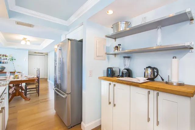 a kitchen with stainless steel appliances a refrigerator and a wooden floor
