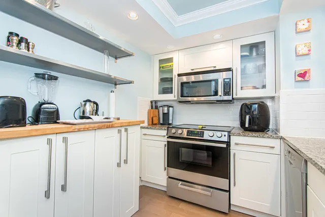 a kitchen with white cabinets and appliances
