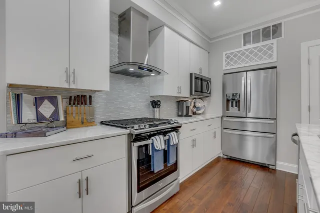 a kitchen with stainless steel appliances granite countertop a refrigerator and a stove top oven
