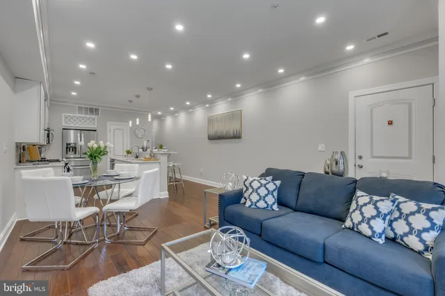 a living room with furniture a kitchen view and a kitchen island