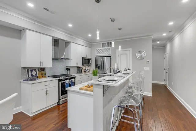 a kitchen that has a lot of cabinets in it and wooden floors