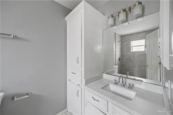 a bathroom with a granite countertop sink and a mirror