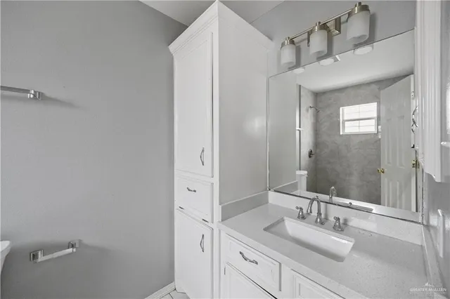a bathroom with a granite countertop sink and a mirror