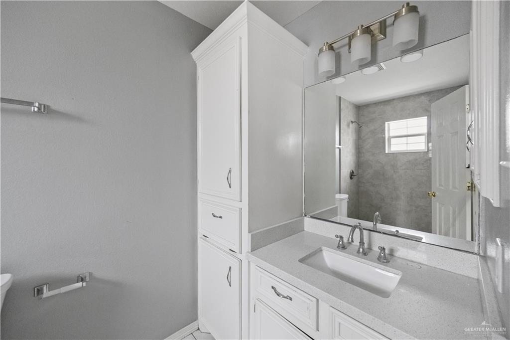 2205 North Erica Street Pharr, TX 78577 - Photo 12 of 21 a bathroom with a granite countertop sink and a mirror