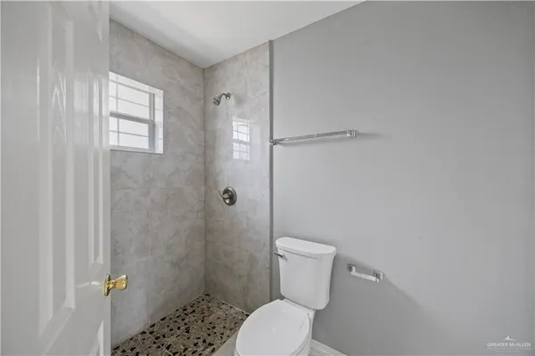 a white toilet sitting next to a shower