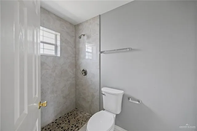 a white toilet sitting next to a shower