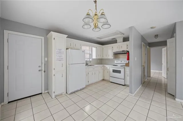 a kitchen with white cabinets and white appliances