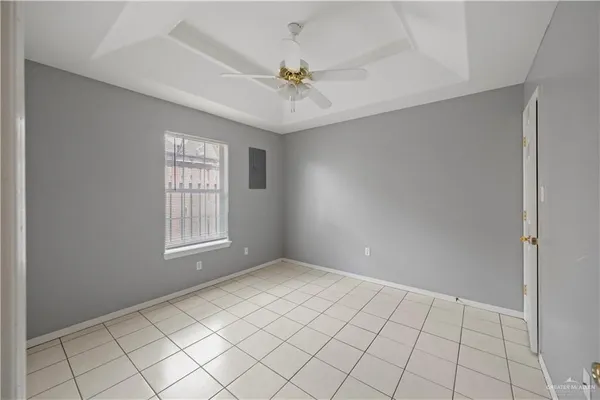 an empty room with windows and fan