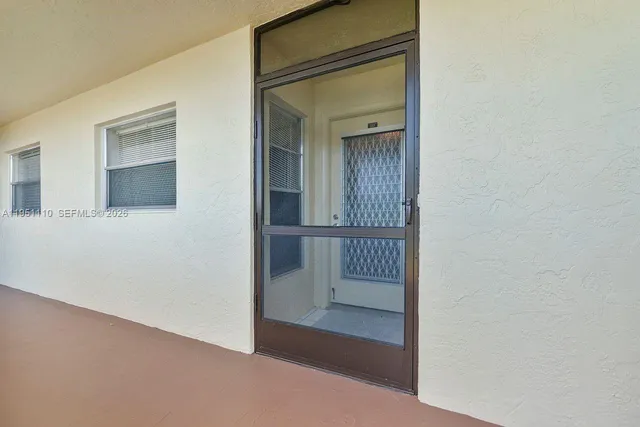 a view of a hallway with wooden floor and entryway