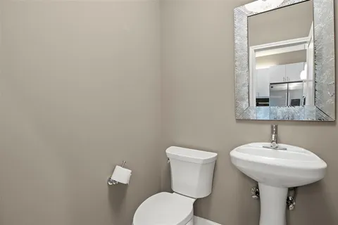 a bathroom with a toilet sink and mirror