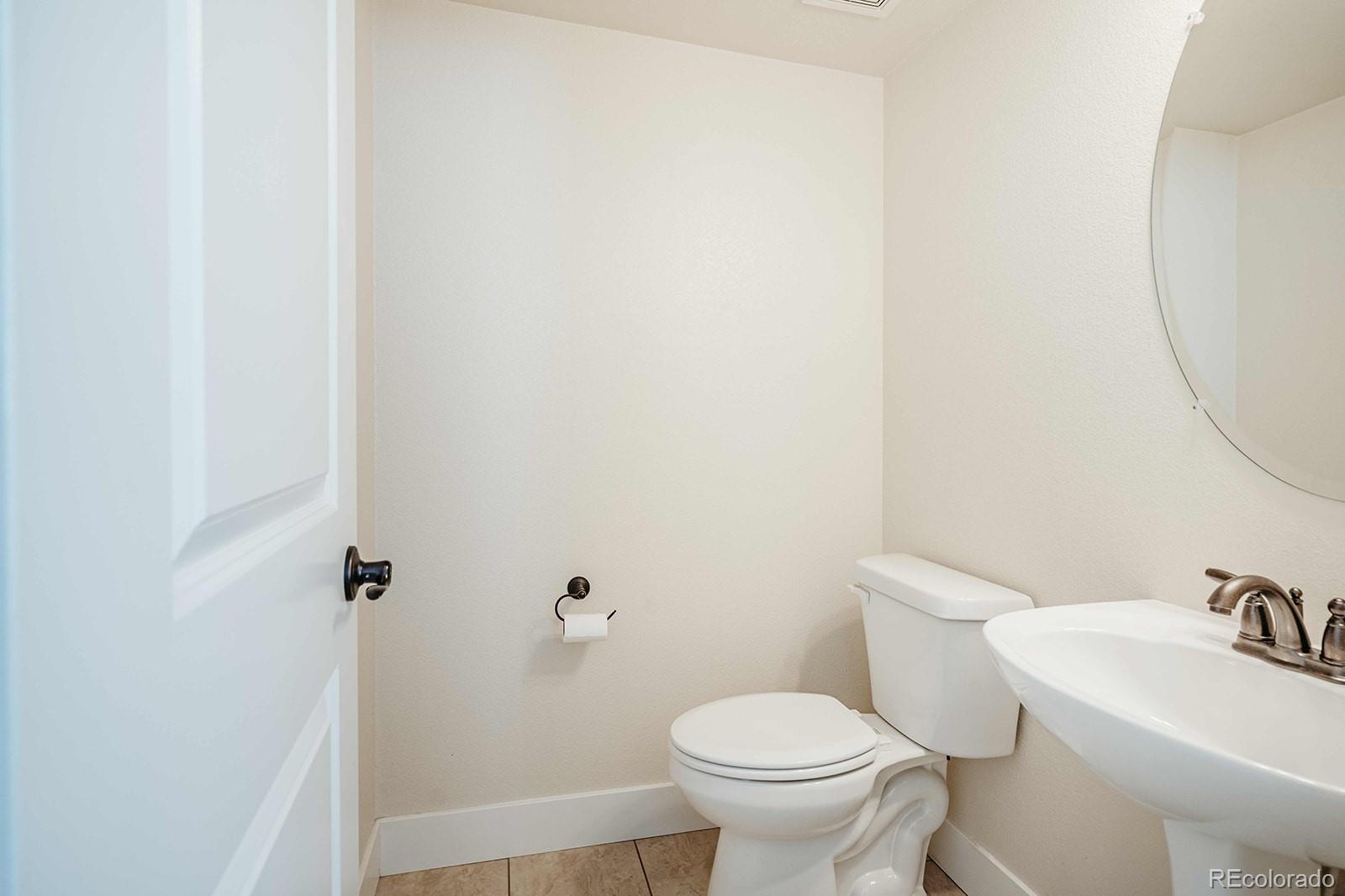 10608 Rutledge Street Parker, CO 80134 - Photo 13 of 24 a white toilet sitting next to a bathroom sink