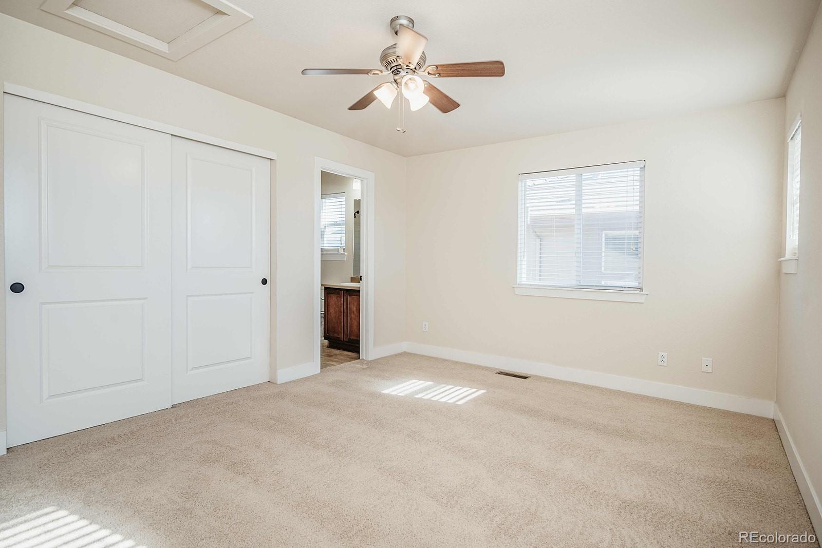 10608 Rutledge Street Parker, CO 80134 - Photo 16 of 24 an empty room with chandelier fan and windows
