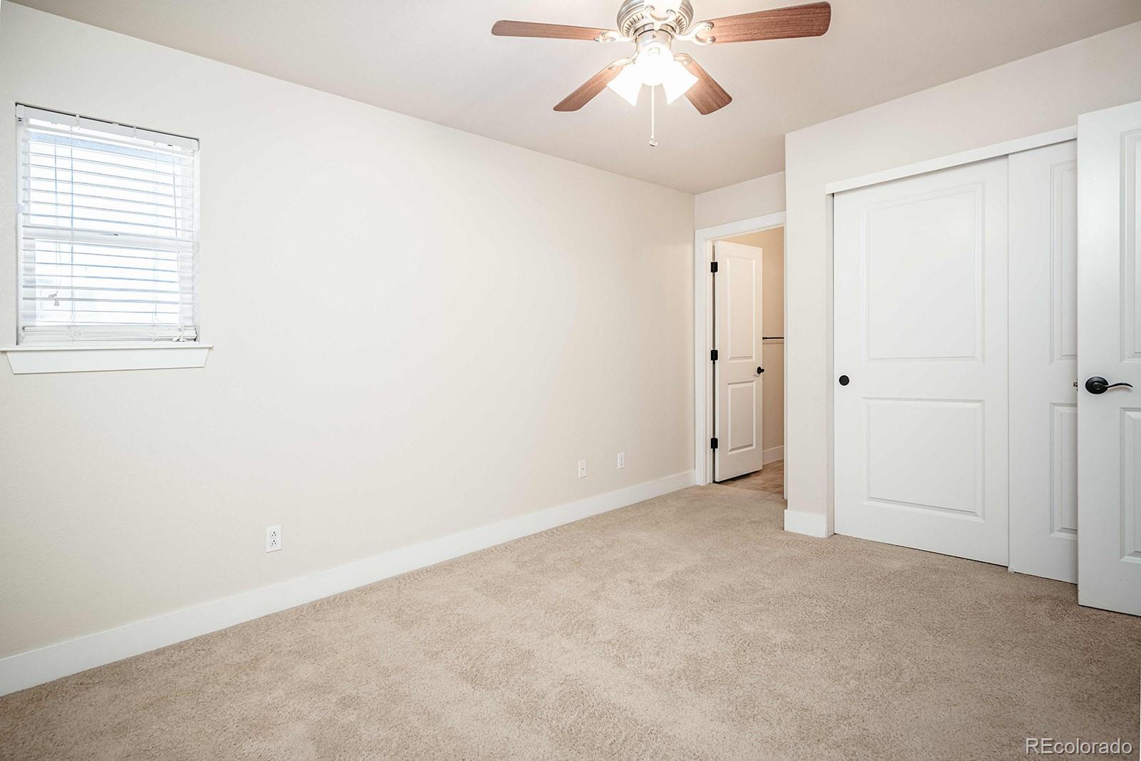 10608 Rutledge Street Parker, CO 80134 - Photo 18 of 24 an empty room with a chandelier fan