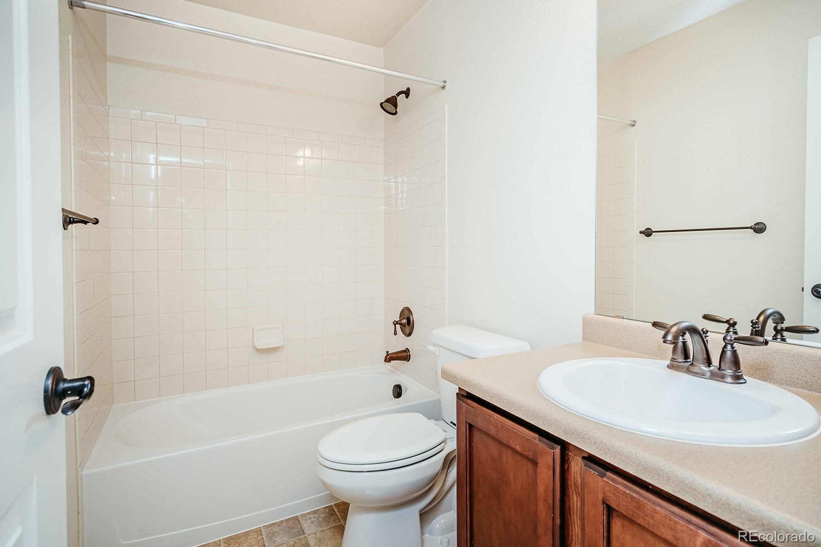 10608 Rutledge Street Parker, CO 80134 - Photo 19 of 24 a bathroom with a sink a toilet and shower