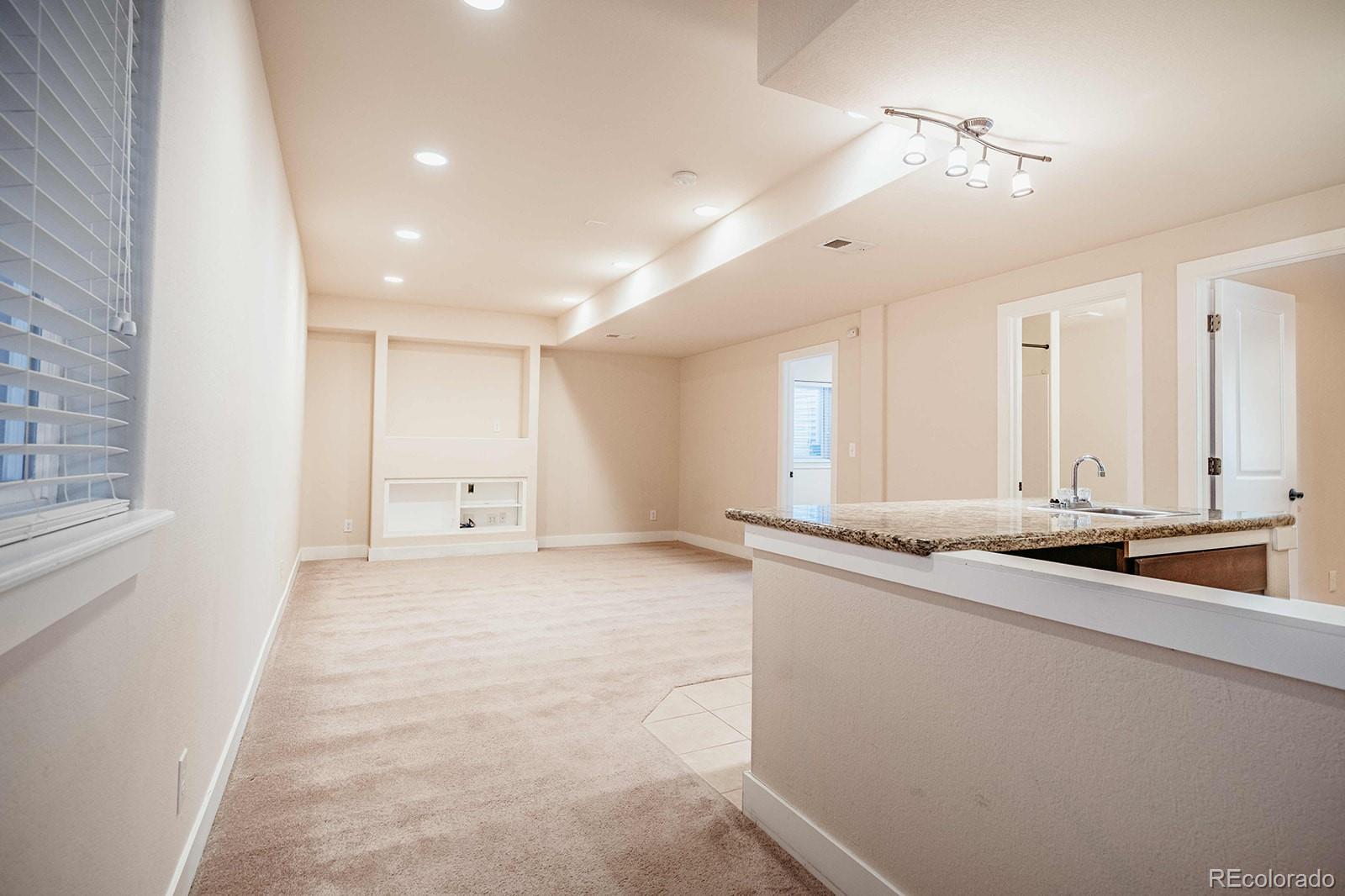 10608 Rutledge Street Parker, CO 80134 - Photo 20 of 24 a kitchen with stainless steel appliances granite countertop a sink and a white cabinets