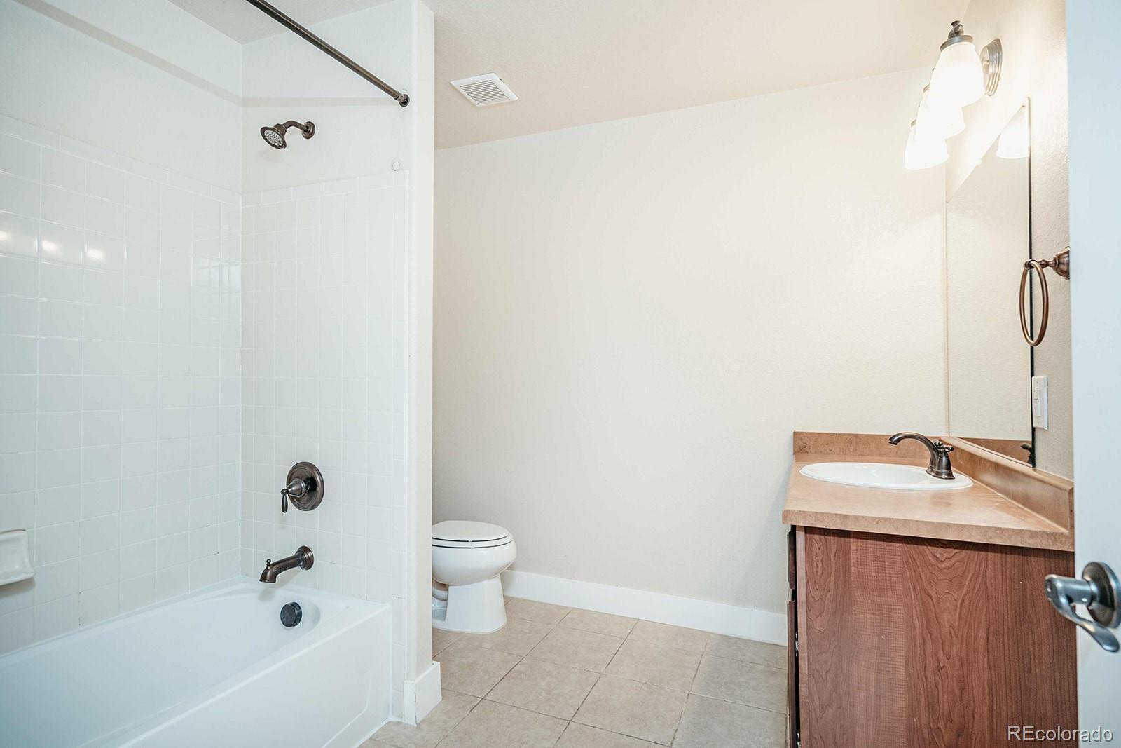 10608 Rutledge Street Parker, CO 80134 - Photo 22 of 24 a bathroom with a sink a toilet and shower
