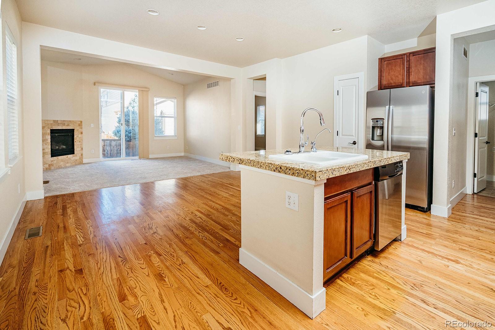 10608 Rutledge Street Parker, CO 80134 - Photo 4 of 24 a view of a kitchen with kitchen island granite countertop wooden floor and stainless steel appliances