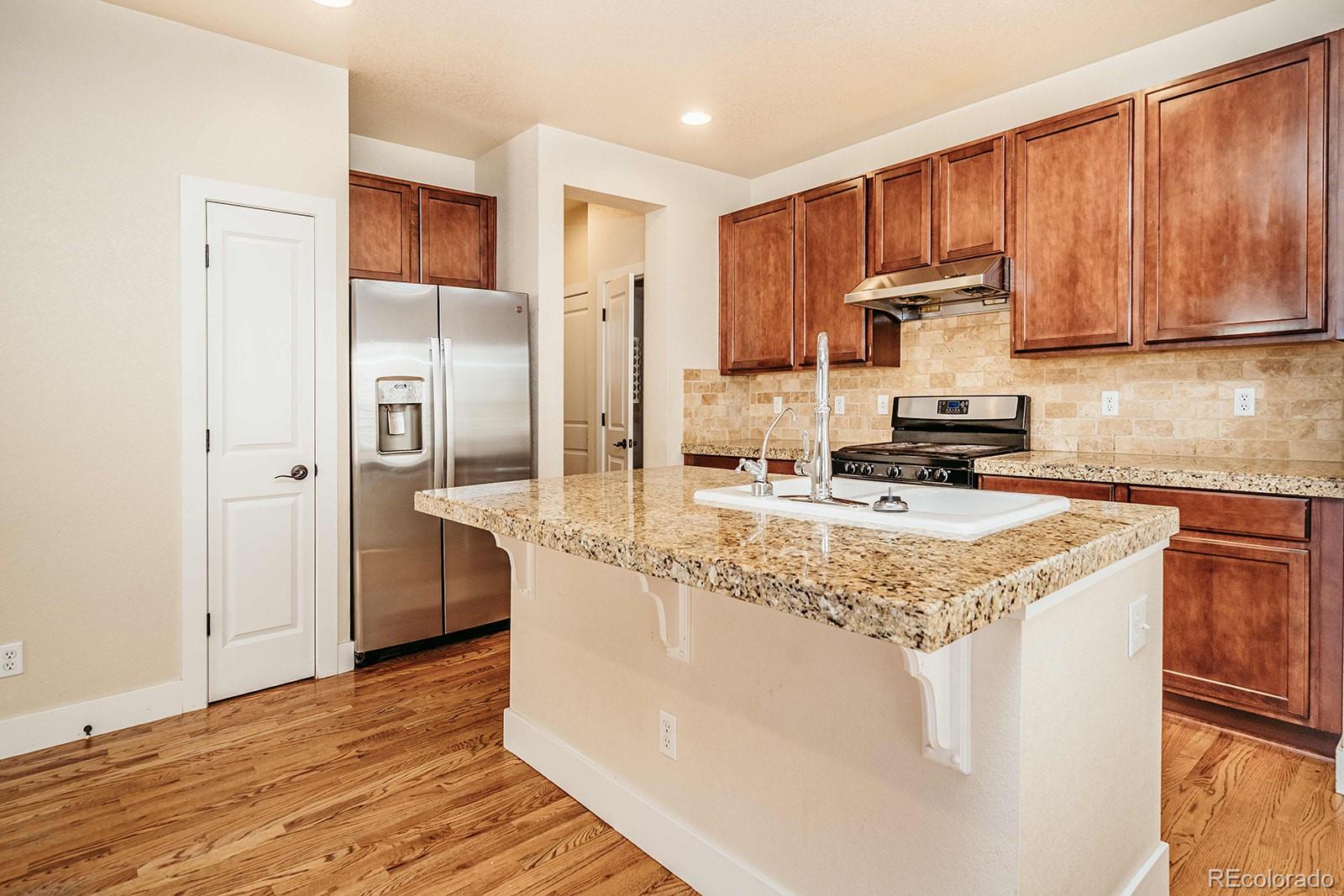 10608 Rutledge Street Parker, CO 80134 - Photo 8 of 24 a kitchen with stainless steel appliances granite countertop a sink stove and refrigerator