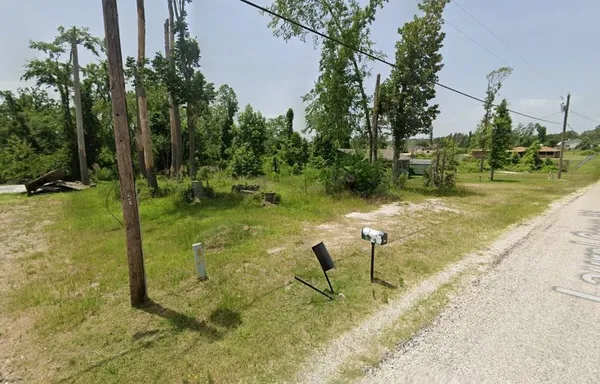 a view of a lake with a bench and trees around