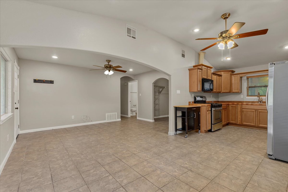 7604 Robalo Road Austin, TX 78757 - Photo 6 of 36 An inviting open-concept living space features a functional kitchen and warm tile flooring throughout.