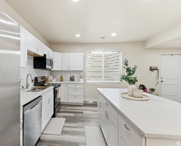 1434 West Stable Street Lindon, UT 84042 - Photo 40 of 76 Kitchen featuring stainless steel appliances, white cabinetry, a kitchen island, light stone counters, and recessed lighting