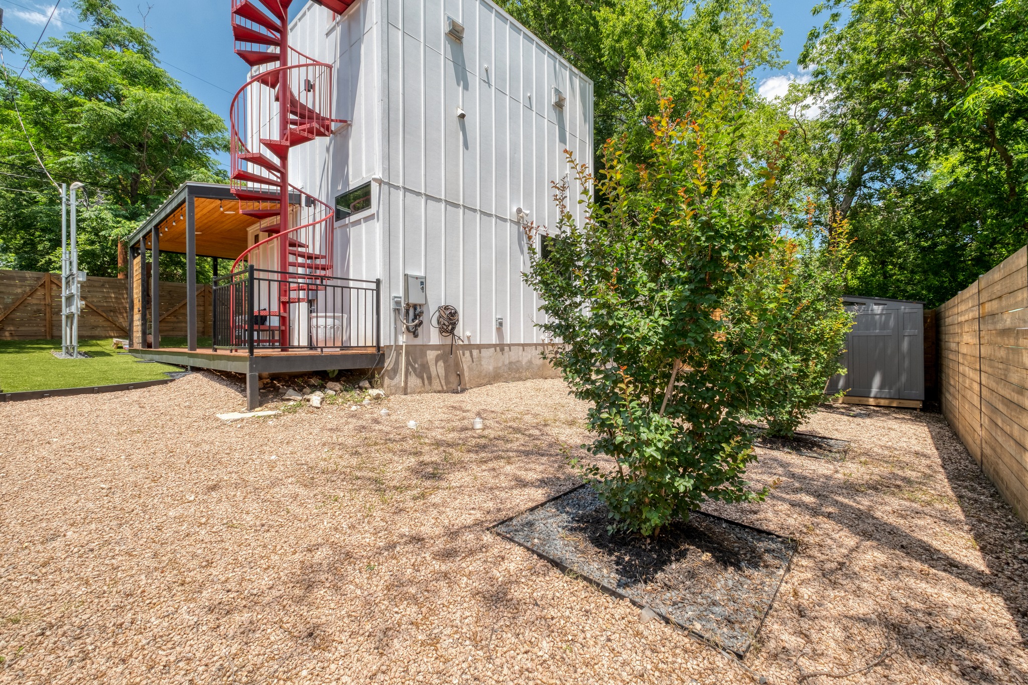 1904 East 16th Street, Unit 2 Austin, TX 78702 - Photo 16 of 20 Exterior features a striking red spiral staircase, a covered outdoor deck with wood-finish ceiling, and a gravel yard
