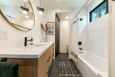 a bathroom with a bathtub a sink and a mirror