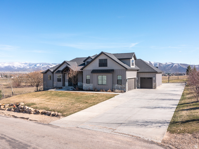 641 West 500 South Midway, UT 84049 - Photo 3 of 52 Modern farmhouse exterior with board and batten siding, stone accents, a dark shingle roof, and multiple dormer windows