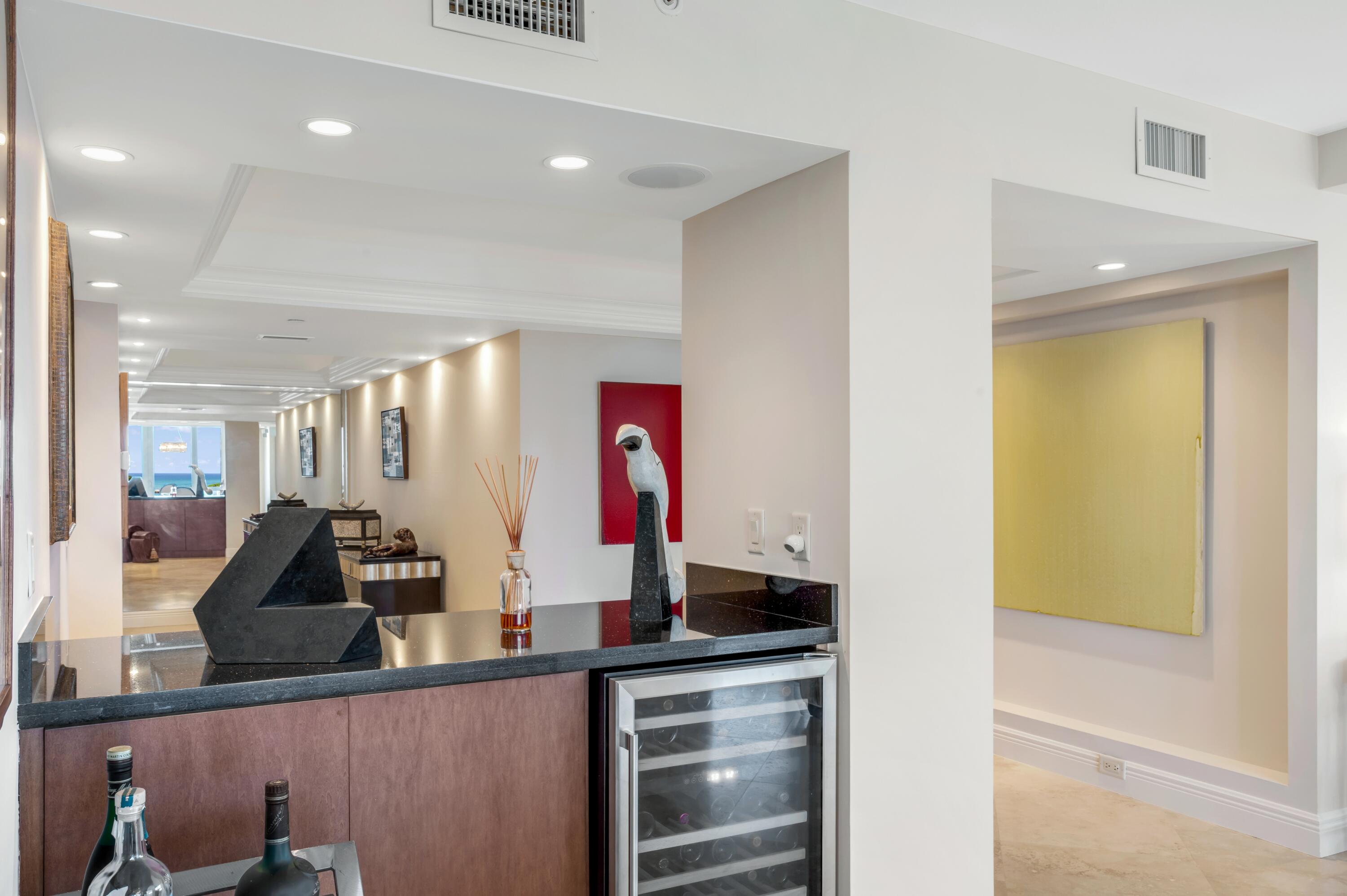 901 East Camino Real, Unit 7C Boca Raton, FL 33432 - Photo 21 of 41 a kitchen with lots of counter top space and two mirrors