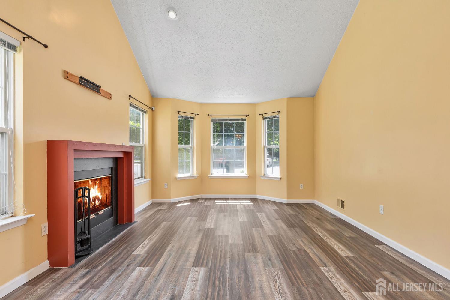 146 Nebula Road Piscataway, NJ 08854 - Photo 6 of 51 a view of an empty room with wooden floor fireplace and a window