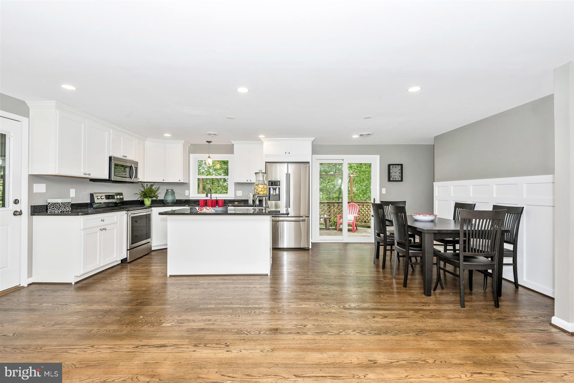 14723 Harrisville Road Mount Airy, MD 21771 - Photo 13 of 29 a kitchen with stainless steel appliances granite countertop a stove top oven a dining table and chairs with wooden floor