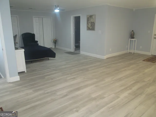 a view of empty room with wooden floor