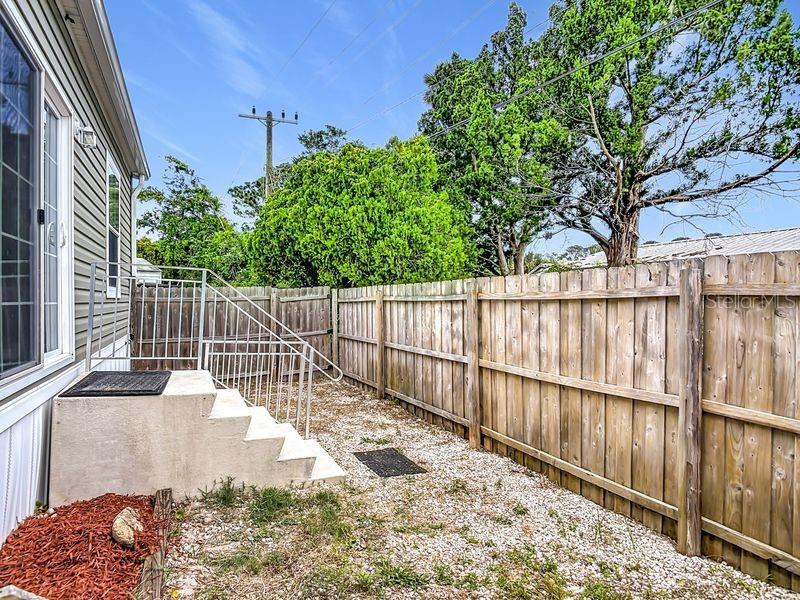 102 Ash Street Edgewater, FL 32141 - Photo 30 of 36 a view of a backyard with a fence and potted plants