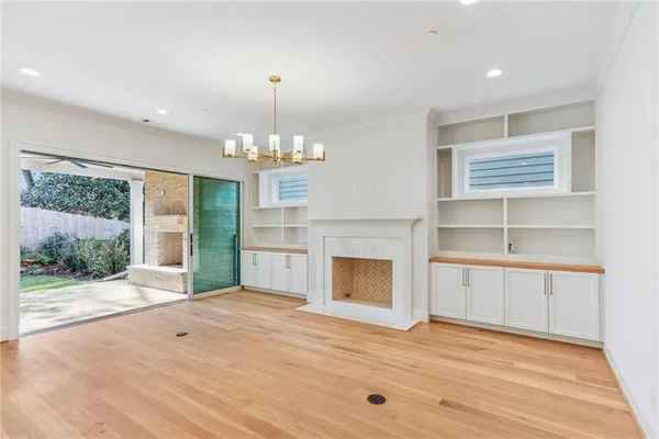 a view of an empty room with a window and kitchen view