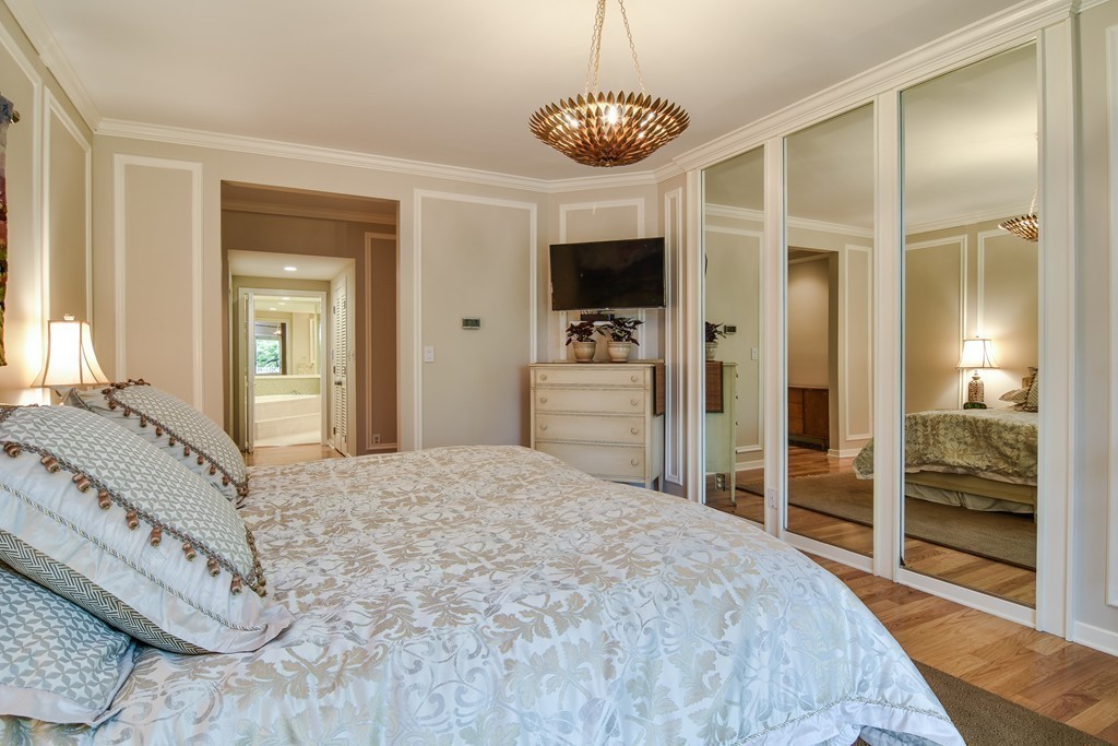 85 Algonquin Road, Unit 85 Chestnut Hill, MA 02467 - Photo 8 of 21 a spacious bedroom with a large bed and a flat tv screen