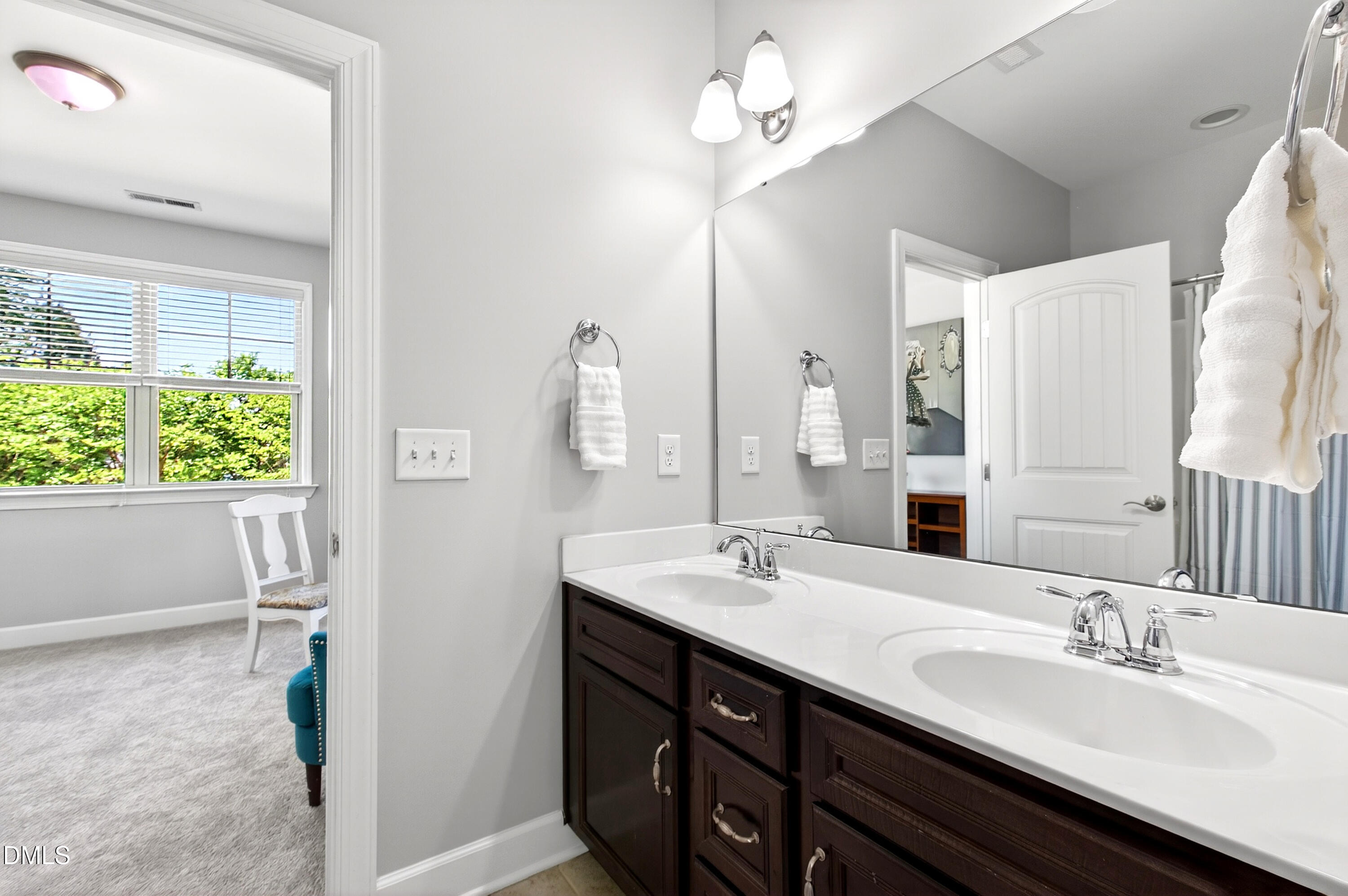 313 Karpen Lane Cary, NC 27519 - Photo 43 of 86 a bathroom with a double vanity sink a mirror and a shower