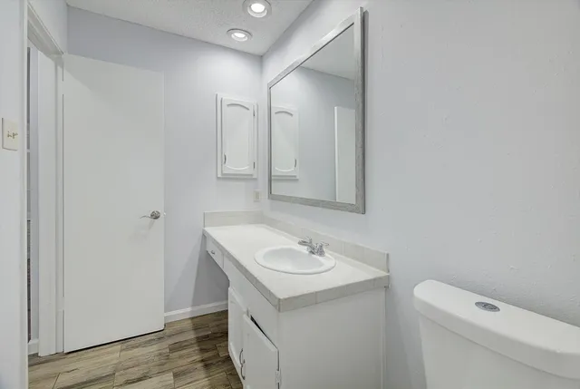 a bathroom with a sink a toilet and a mirror