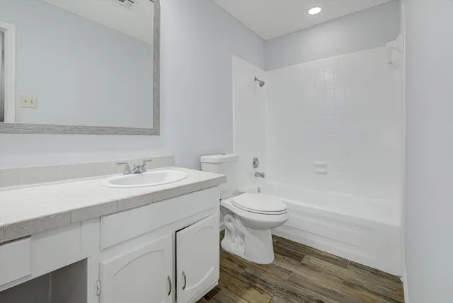 a bathroom with a white toilet sitting next to a bathroom sink and a shower
