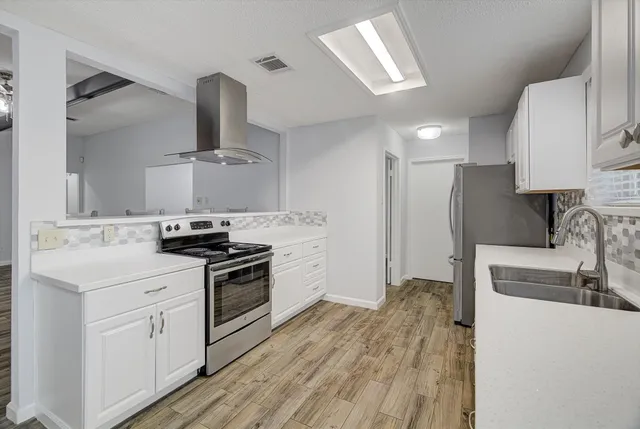 a kitchen with a stove a sink and a refrigerator
